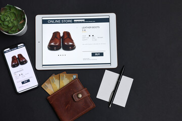 Online shopping. Flat lay composition with modern tablet and smartphone on black background