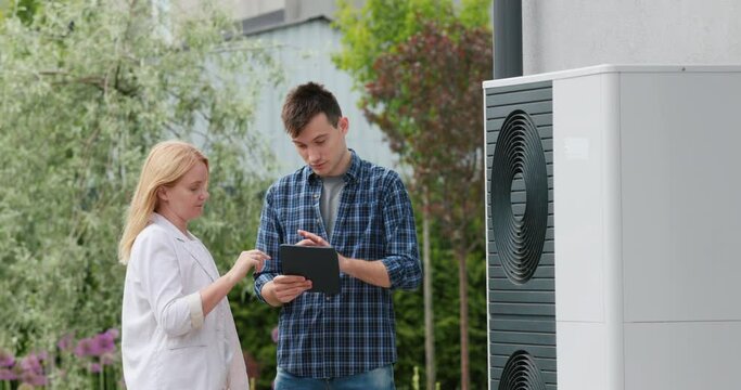 A young engineer advises a client in setting up a heat pump