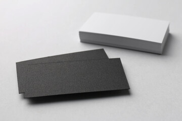 Blank black and white business cards on light background, closeup. Mockup for design