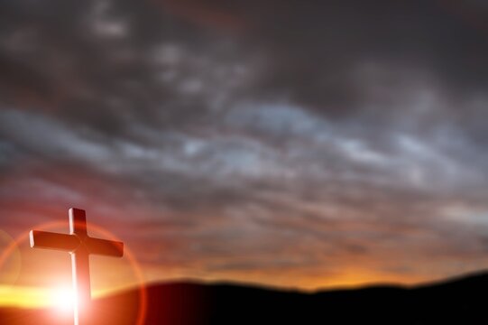 Holy wooden cross on sunset background
