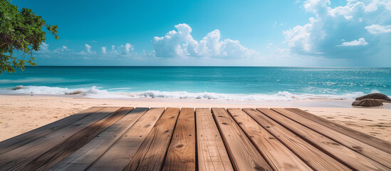Empty wooden table or deck at the front overlooking vast sandy beach and turquoise sea or ocean water. Copy space mockup 