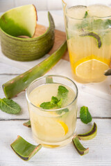 Aloe lemonade, homemade detox drink with lemon, aloe vera and mint on white wooden background copy space