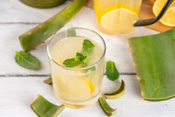 Aloe lemonade, homemade detox drink with lemon, aloe vera and mint on white wooden background copy space