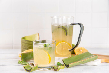 Aloe lemonade, homemade detox drink with lemon, aloe vera and mint on white wooden background copy space