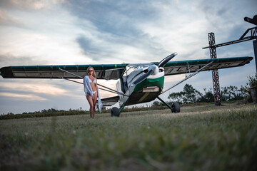 modelo latina junto a una avioneta al atardecer