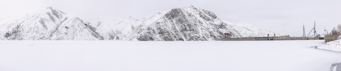 panoramic view of a white snow-capped mountain ridge in front of a lake in Ludu

