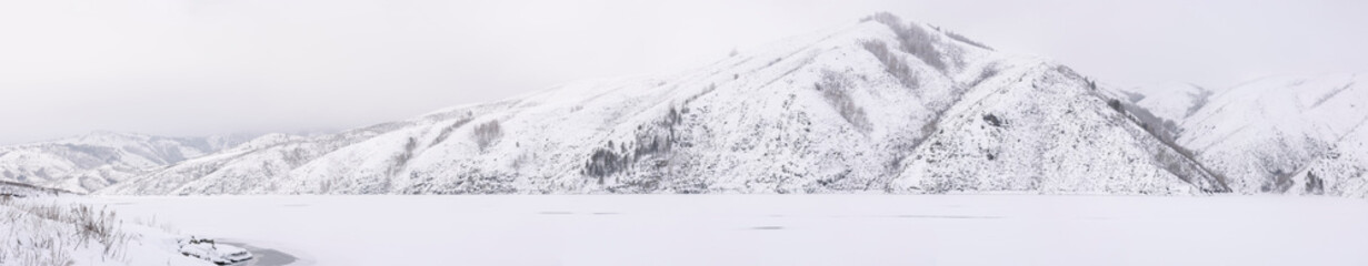 panoramic view of a white snow-capped mountain ridge in front of a lake in Ludu

