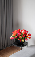 Flowers in the modern home interior.  Stylish home decor. Luxury  grey iving room.