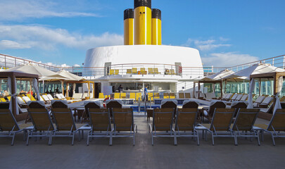 Deck chairs or sun loungers on balcony or terrace or patio pool deck of luxury modern cruise ship...