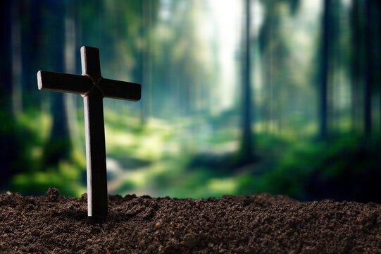 Praying wooden cross in soil outdoor