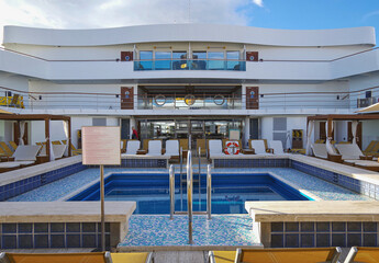 Deck chairs or sun loungers on balcony or terrace or patio pool deck of luxury modern cruise ship...