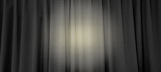 close up view of dark black in thin and thick vertical folds made of black out sackcloth fabric, panoramic view. grey curtain background with yellow spotlight at center in theater or cinema.