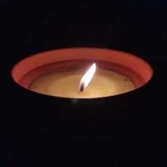 Vela encendida en plena oscuridad.