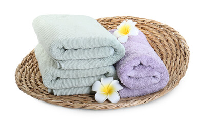 Fototapeta na wymiar Different folded soft towels and plumeria flowers isolated on white
