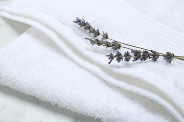 Terry towel and dry flowers on white table, closeup