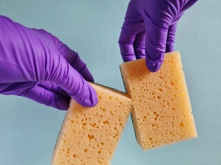 Hands in glove holding sponge