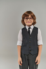 stylish boy stands confidently, shirt buttoned up to collar and vest adding a touch to his look
