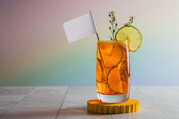 orange cocktail with pennant lemon and flowers on rainbow colored background