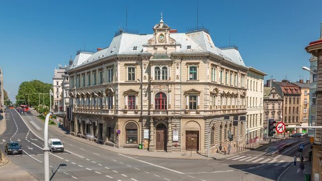Busy traffic on intersection near Chrobry Square in Bielsko-Biala timelapse, Poland. Historic buildings aerial view from Sulkowski Castle. People crossing the road. Sunny day with a blue sky