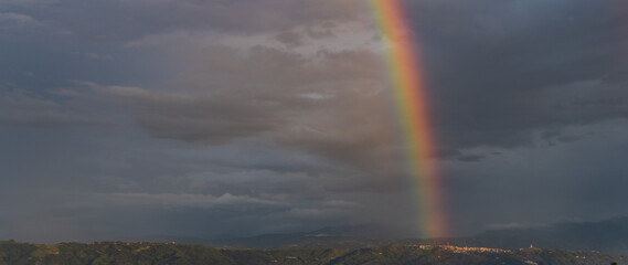 imagen del cielo y las nubes con una parte del arco iris en el fondo 