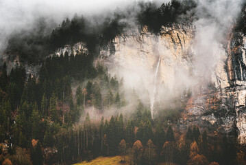 Fog in the mountains with waterfall in Lauterbrunnen of Switzerland
