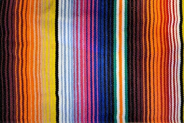 Traditional woven Mexican blanket with colorful vertical striped pattern 