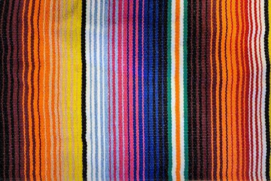 Traditional woven Mexican blanket with colorful vertical striped pattern 