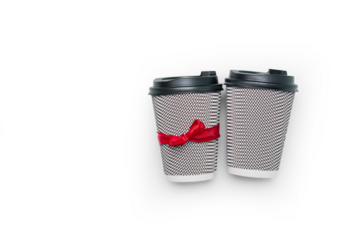 Two disposable coffee cups with a black and white pattern and a red ribbon on a transparent background with shadow.