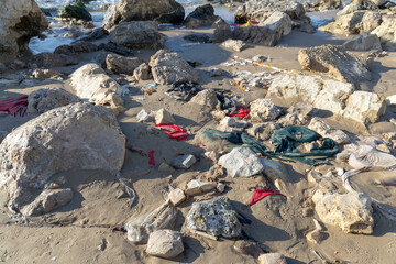 Garbage washed ashore after a storm. Pieces of cloth and plastic bags. Environmental pollution...