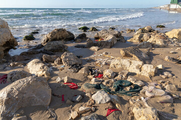 Garbage washed ashore after a storm. Pieces of cloth and plastic bags. Environmental pollution washes ashore Bat Yam Israel Winter