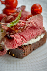Toast with roast beef and vegetables in a plate
