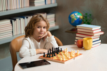 Little child chessman play chess game, checkmate. Kid playing chess in the room. Brain development...