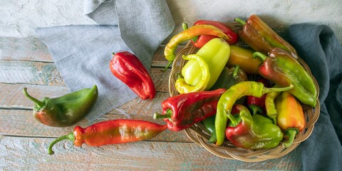 Red and green peppers, on wooden background, seasonal organic vegetables 