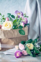A beautiful bouquet of pink roses in a craft paper bag, still life