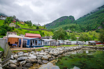 Camping site on the coast of Geirangerfjord in town Geiranger, one of the most beautiful fjords in Norway - obrazy, fototapety, plakaty