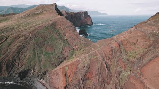 Aerial flight at the spectacular Vereda da Ponta de  Sao Lourenco Hike, Madeira, Portugal. Drone flying an approach and tilting up with unrecognizable hikers in the foreground.