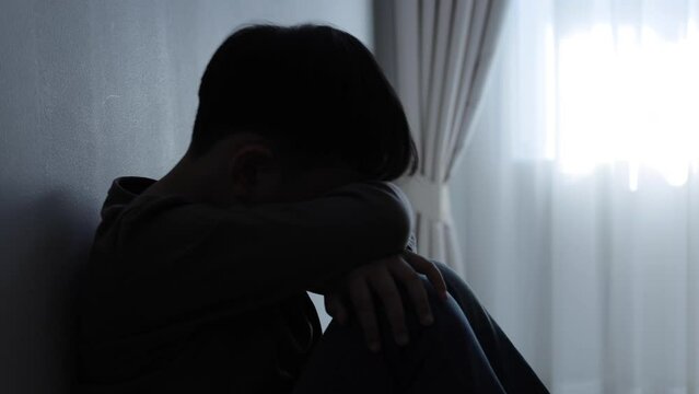 The child is sitting sadly in the house.