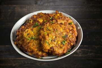 Top view of a plate of corn fritters.Perkedel Jagung or Bakwan Jagung. Corn fritters is Indonesian traditional food. Savory snack made of corn, flour, spring onion, and salt. Vegetarian food,Thai food