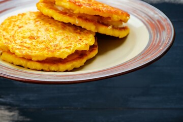 Corn Fritters with Corn. Healthy and Diet Food . Crispy fried corn ball in a white plate on wooden table, Vegetarian food, Thai food, snacks Thai style. Zucchini fritters or vegetarian zucchini pancak