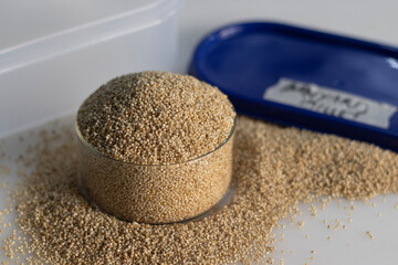 Closeup of banyard millet, a healthy grain, in a container and glass bowl filled to the brim