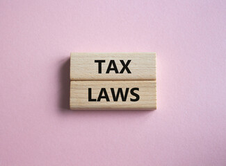 Tax Laws symbol. Concept word Tax Laws on wooden blocks. Beautiful pink background. Business and Tax Laws concept. Copy space