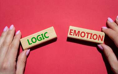 Logic or Emotion symbol. Concept word Logic or Emotion on wooden blocks. Businessman hand. Beautiful red background. Business and Logic or Emotion concept. Copy space