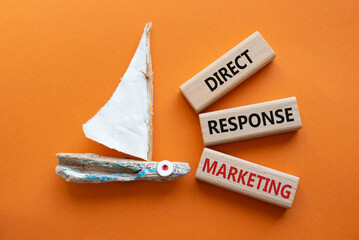 Direct Response Marketing symbol. Concept words Direct Response Marketing on wooden blocks. Beautiful orange background with boat. Business and Direct Response Marketing concept. Copy space. - obrazy, fototapety, plakaty