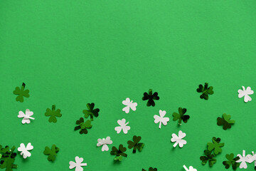 Saint Patrick's Day green background with green and white shamrock or four-leaf clover confetti,...