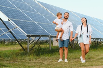 Obraz premium Happy family near solar panels. Alternative energy source