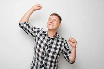 Portrait of smiling face man clenching fists and rejoicing, celebrating victory isolated on white...