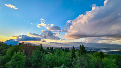 Obraz premium Scenic sunset view of mount Dobratsch and Lake Faak seen from Altfinkenstein at Baumgartnerhoehe, Carinthia, Austria. Tranquility on hiking trail. Overlooking Villach area surrounded by Austrian Alps