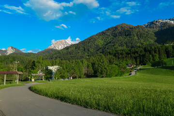 Fototapeta na wymiar Idyllic alpine road with scenic view of majestic mountain peak Mittagskogel in Karawanks seen from Altfinkenstein at Baumgartnerhoehe, Carinthia, Austria. Tranquility on hiking trail in Austrian Alps