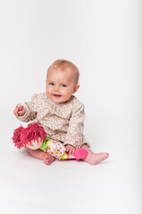Little baby sitting on the floor with doll