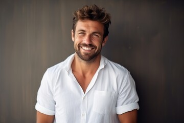 Portrait of a handsome young man smiling and looking at the camera - obrazy, fototapety, plakaty